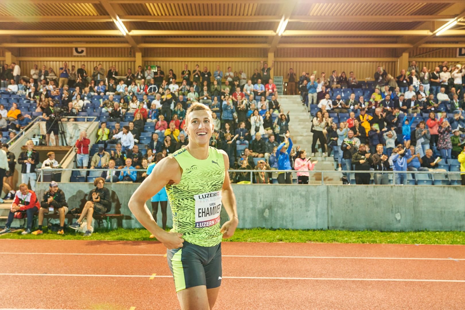 Leichtathletik-Läufer Ehammer im Fokus mit Publikum im Hintergrund